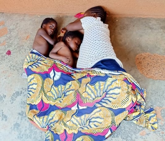 Solange e le sue bambine, mentre dormono sul battuto dell'ingesso al centro di salute di Kanyaka gestito da AMKA Onlus.
